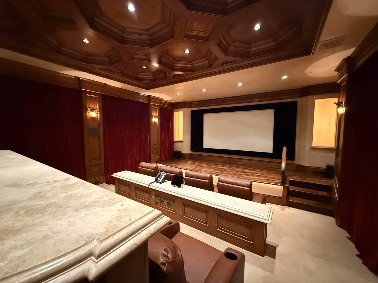 A Glimpse Into Atherton's Finest: The Private Theater
In Atherton, the zip code alone speaks volumes. But within the gates of this extraordinary estate, it is the details that tell the real story.
Imagine a Friday evening. The week's last board meeting has ended. The car glides through tree-lined lanes into the privacy of your own domain. Tonight, there are no reservations to make, no valet lines, no crowded lobbies. Tonight, the theater comes to you.
Descend into a room that would quiet even the most seasoned traveler — hand-crafted coffered ceilings in rich mahogany, crimson velvet curtains drawn like those of a grand European cinema, the warm flicker of brass wall sconces casting a glow that feels almost ceremonial. Settle into butter-soft leather, a chilled glass within reach on the marble console beside you. The lights dim. The screen fills. The world outside disappears entirely.
This is the quiet privilege that Atherton's ultra-luxury estates are legendary for — not spectacle for its own sake, but the seamless, effortless elevation of everyday life. Where the extraordinary becomes simply Tuesday.
For the Silicon Valley executive who has built something remarkable, this is the home that reflects it.