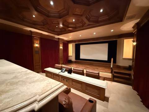 A Glimpse Into Atherton's Finest:  The Private Theater

In Atherton, the zip code alone speaks volumes. But within the gates of this extraordinary estate, it is the details that tell the real story.
Imagine a Friday evening. The week's last board meeting has ended. The car glides through tree-lined lanes into the privacy of your own domain. Tonight, there are no reservations to make, no valet lines, no crowded lobbies. Tonight, the theater comes to you.
Descend into a room that would quiet even the most seasoned traveler — hand-crafted coffered ceilings in rich mahogany, crimson velvet curtains drawn like those of a grand European cinema, the warm flicker of brass wall sconces casting a glow that feels almost ceremonial. Settle into butter-soft leather, a chilled glass within reach on the marble console beside you. The lights dim. The screen fills. The world outside disappears entirely.
This is the quiet privilege that Atherton's ultra-luxury estates are legendary for — not spectacle for its own sake, but the seamless, effortless elevation of everyday life. Where the extraordinary becomes simply Tuesday.
For the Silicon Valley executive who has built something remarkable, this is the home that reflects it.
